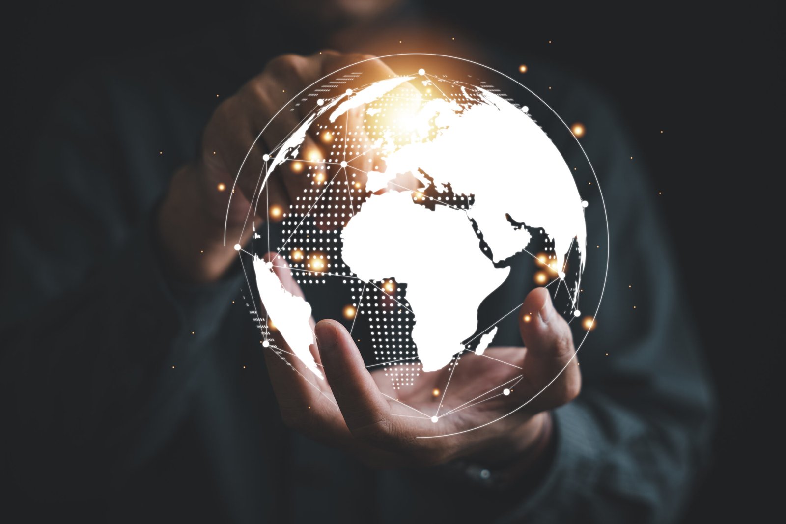 a businessman's hand holds a globe, illustrating seamless connec